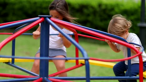 children playing at playground caroussel. kids spinning around outdoors