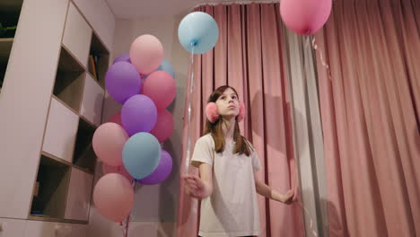 Niña jugando con globos.