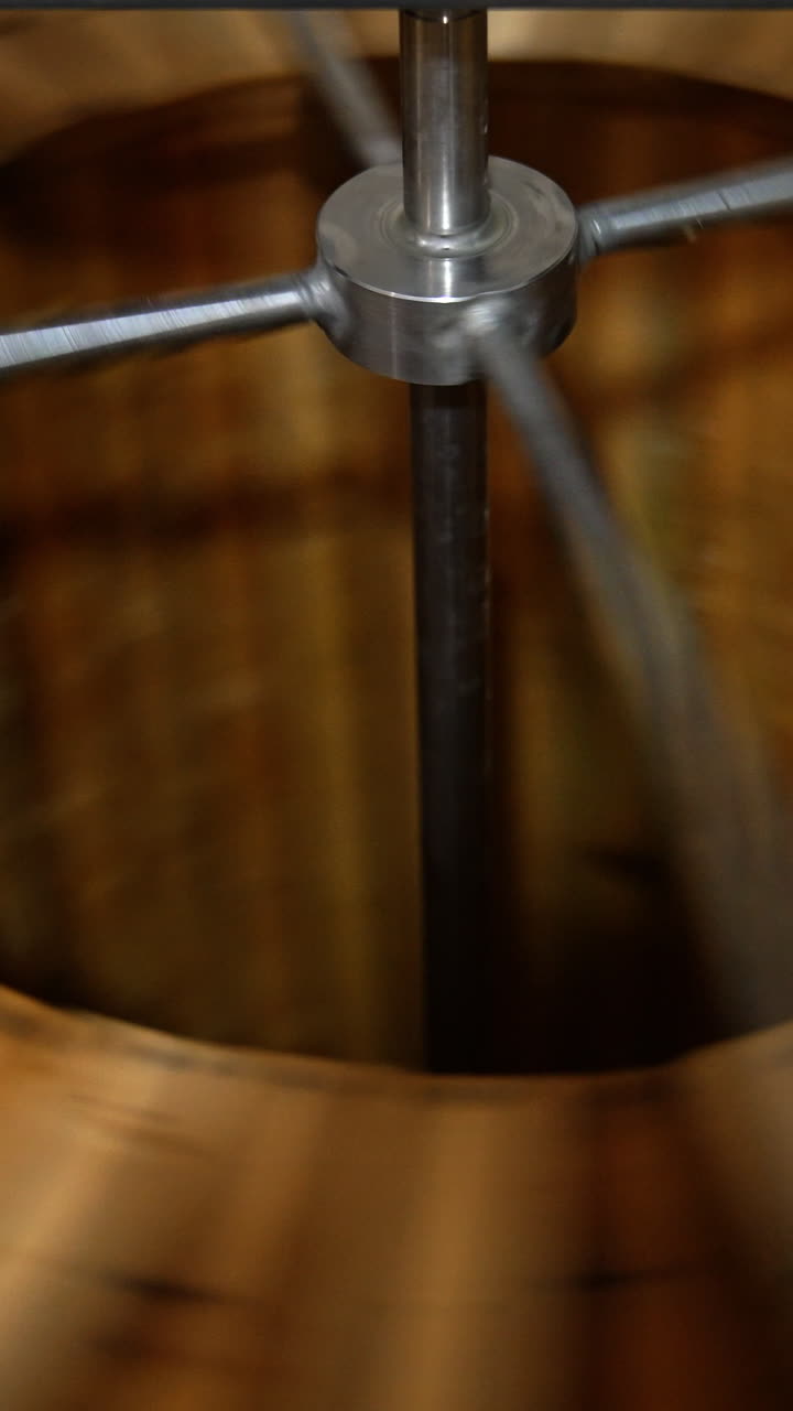 Centrifuge rotating quickly to extract honey from frames. Apiary machine for harvesting organic fresh honey. Vertical video