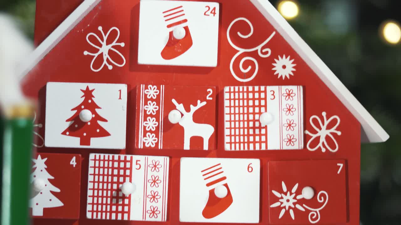 calendario de adviento de árbol de madera frente a un árbol de navidad real decorado juguetes de soldado cascanueces