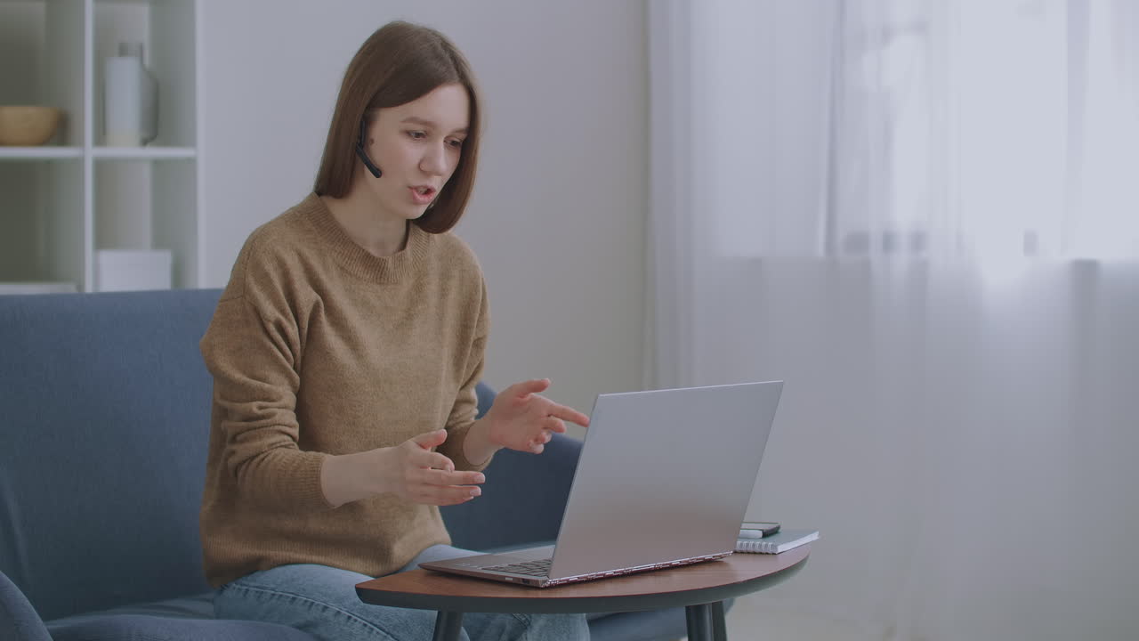 woman is communicating online using laptop with internet and headphones with microphone online chat tech support