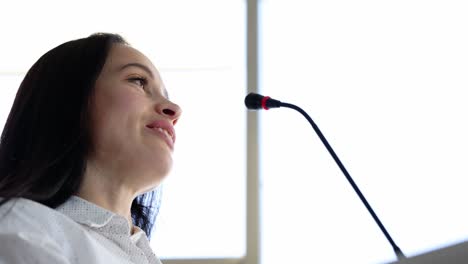 woman giving a speech into a microphone