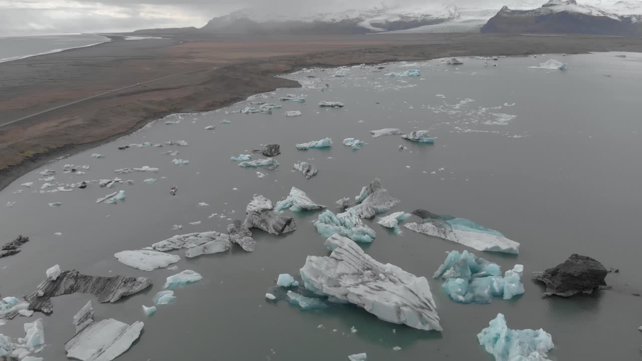 관광객과 스피드 보트가 있는 빙하 석호의 공중 패닝 샷