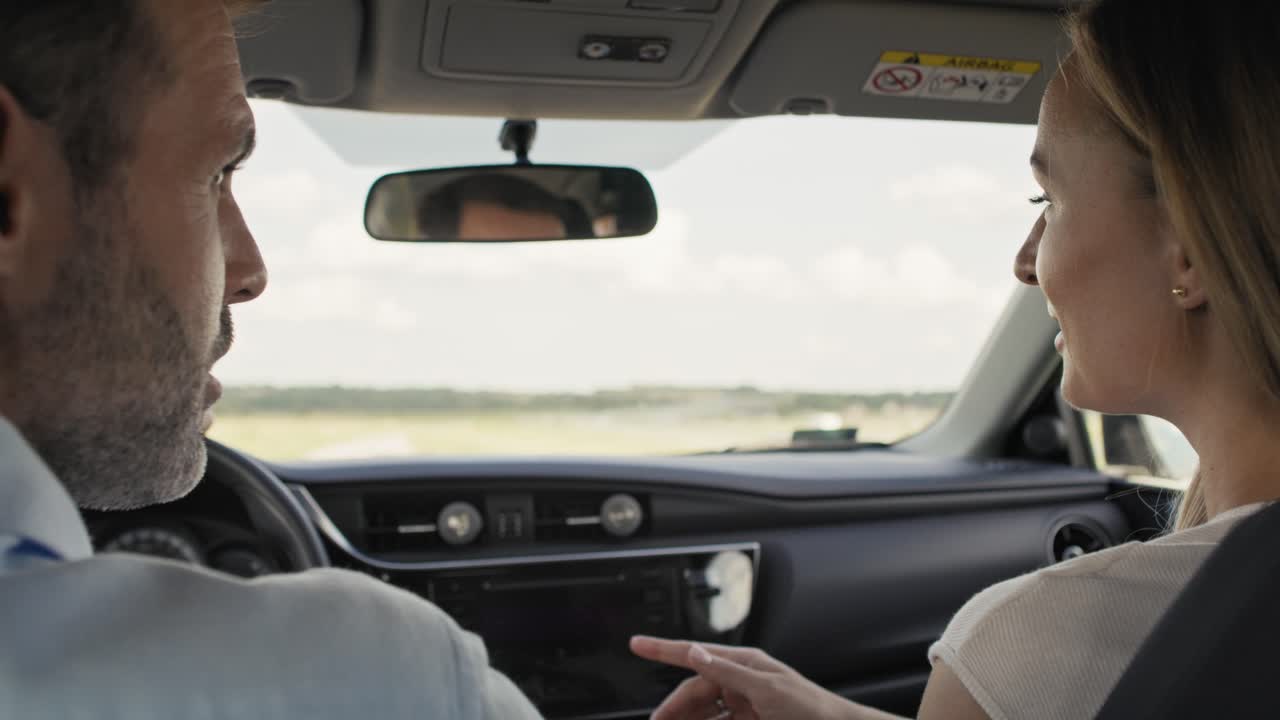 vista posterior de una alegre pareja caucásica de mediana edad durante un viaje en coche.