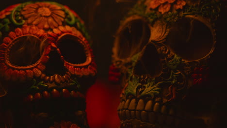 close up on still life of decorated skulls with mist or smoke celebrating mexican holiday of dia de muertos or day of the dead