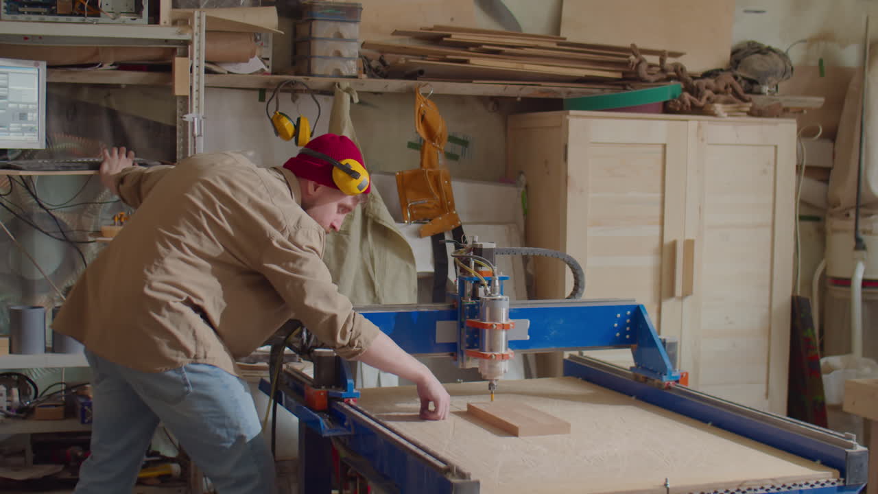 Woodworker Operating CNC Machine with Computer