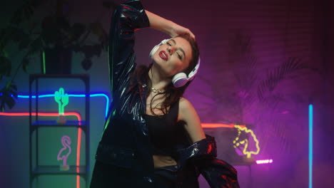 Brunette-Female-Dancer-In-Headphones-Dancing-While-Listening-To-Music-In-Futuristic-Room-Looking-At-Camera