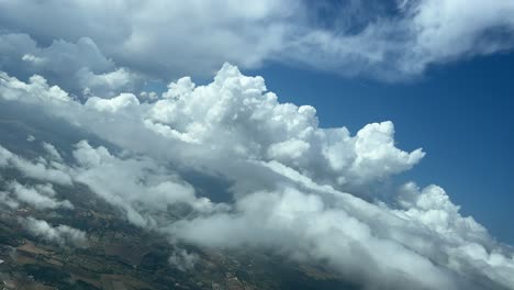 Tolle-Aussicht-Aus-Der-Kabine-Eines-Flugzeugs-Während-Einer-Linkskurve,-Die-Durch-Eine-Winzige-Kumuluswolke-Fliegt