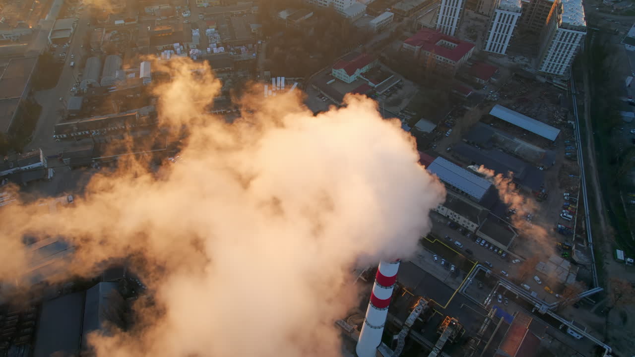 Aerial drone view of thermal power plant in Chisinau at sunrise, Moldova. View of pipe with felling steam, cityscape