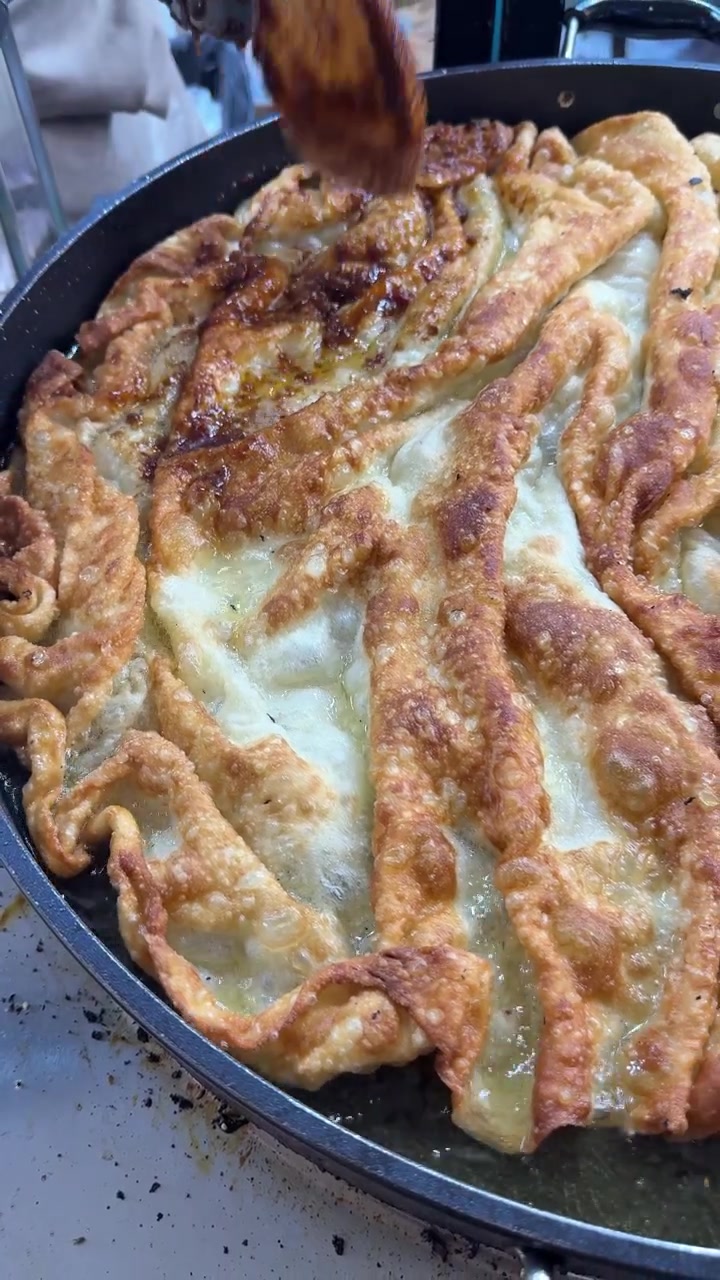 Chef Frying Traditional Flatbread in a Large Pan