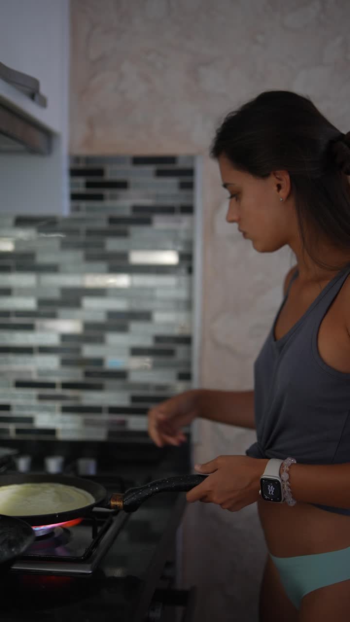 mujer cocinando panqueques en una cocina