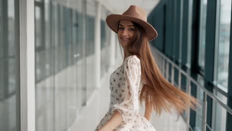 Retrato-De-Una-Chica-Alegre-Con-Un-Vestido-Ligero-Y-Un-Sombrero-Bellamente-Girando-Y-Posando