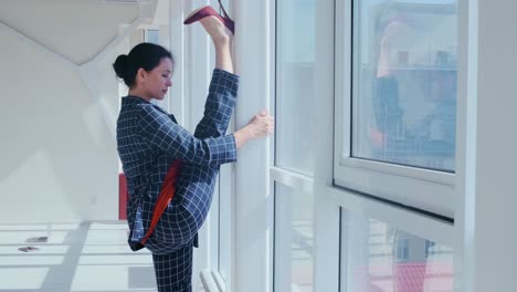 businesswoman stretching by window