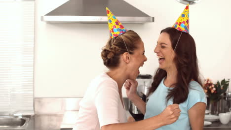 Two-friends-dancing-together-in-the-kitchen