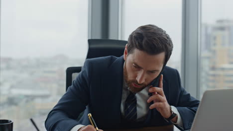 busy employee talking phone with boss noting work issues in notebook close up.