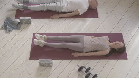 old male and female exercising on yoga mat at home