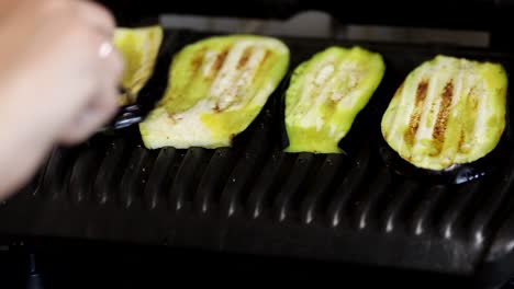 flipping aubergine slices on a grill