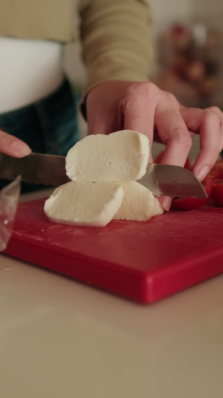 Woman Slicing Mozzarella for Fresh Salad. Healthy food close up