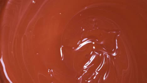 strawberries being dipped into melted chocolate