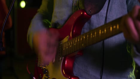 Man-playing-electric-guitar-in-a-music-studio