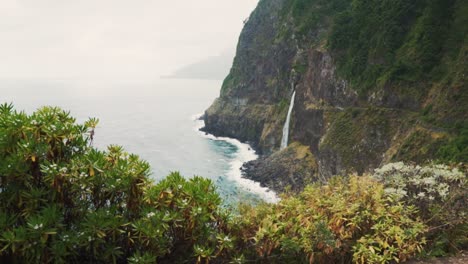 dramatic waterfall cascading down cliffside to ocean view