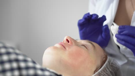 procedimiento de hardware en cosmetología. el cosmetólogo suaviza las arrugas con microcorrientes. peeling, fonoforesis, masaje y lifting facial en una clínica de belleza.