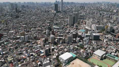 aerial scenic urban drone footage of a neighborhood, streets and buildings in the capital city of tokyo, japan on a sunny day