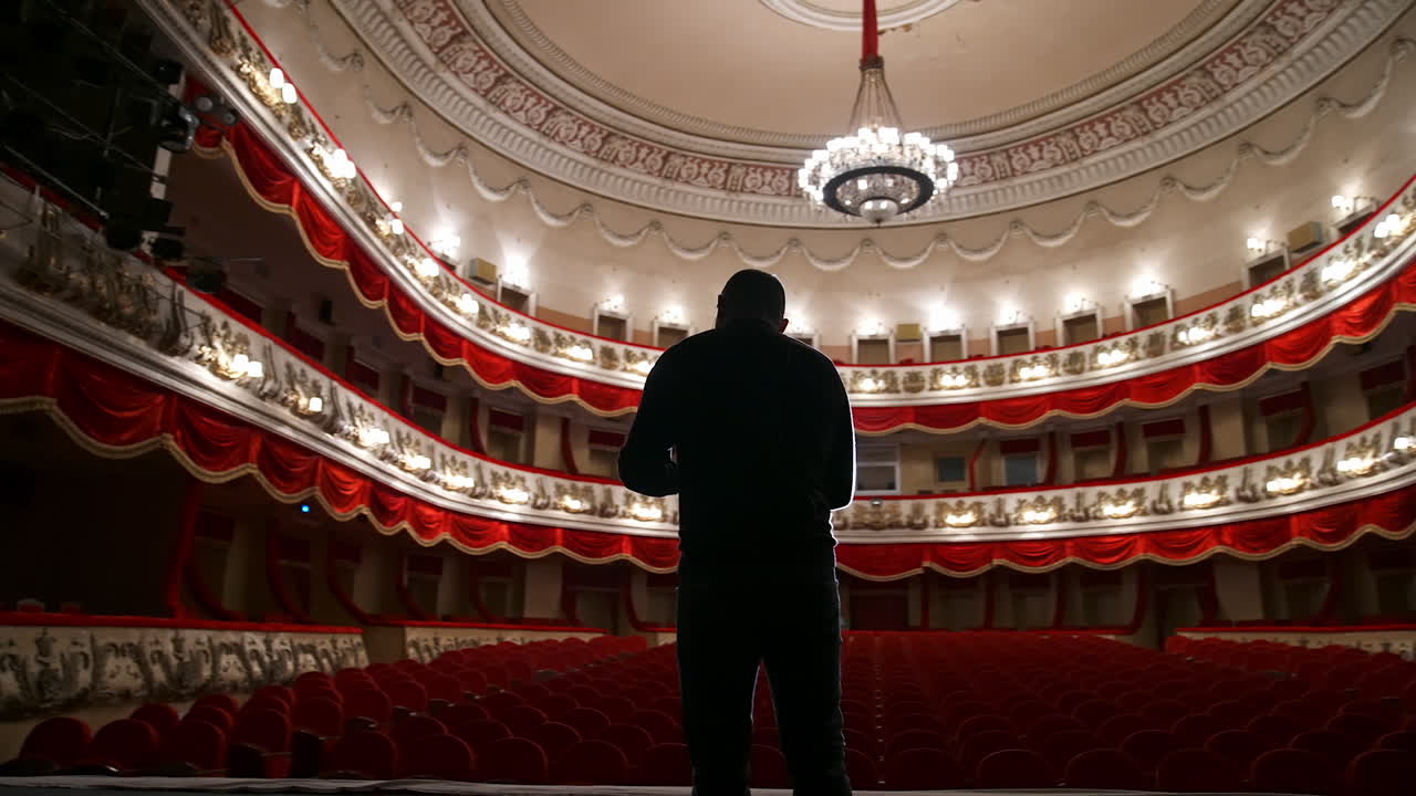 Successful Motivational Speaker. Empty classic theater. No people in hall because of pandemic.