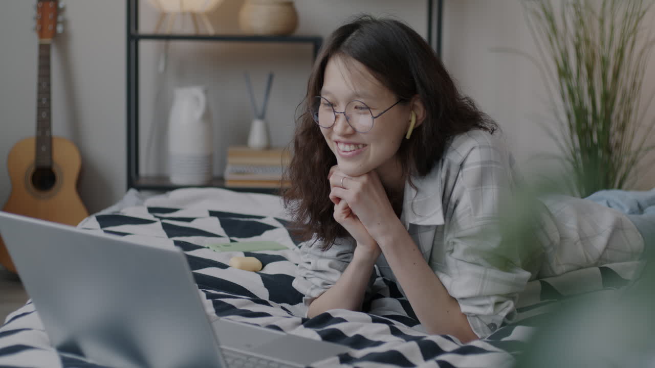 Young Woman Having a Video Call on Laptop in Bedroom