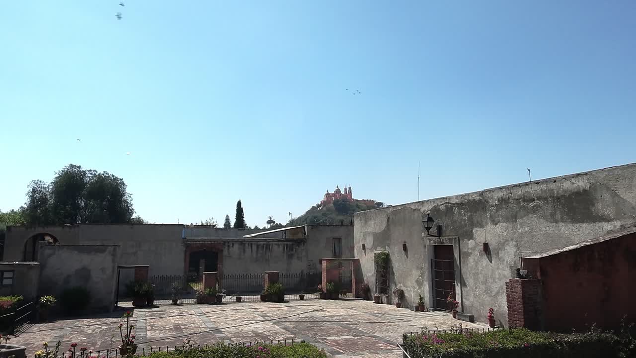 Vista panoramica del cortile di Cholula con una chiesa in lontananza in una giornata di sole.