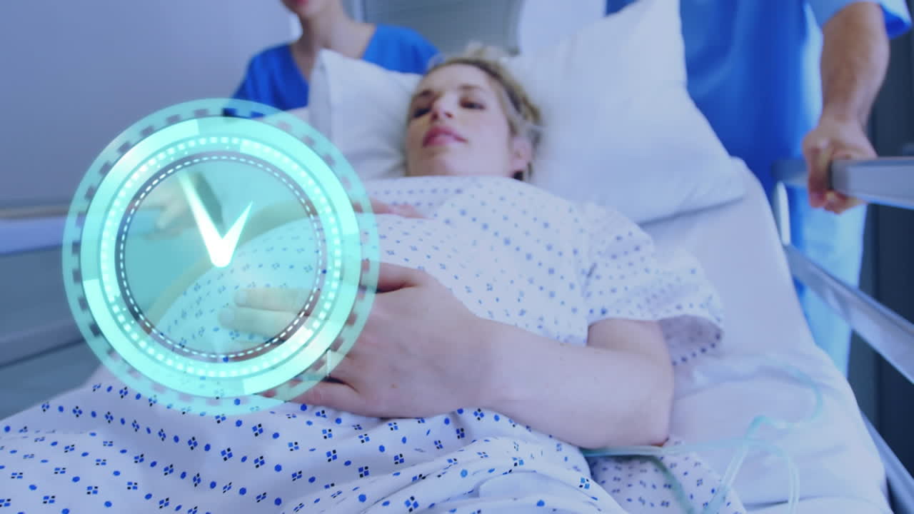 침대에 있는 임신한 백인 여성이 병원 복도에서 빠르게 움직이는 시계