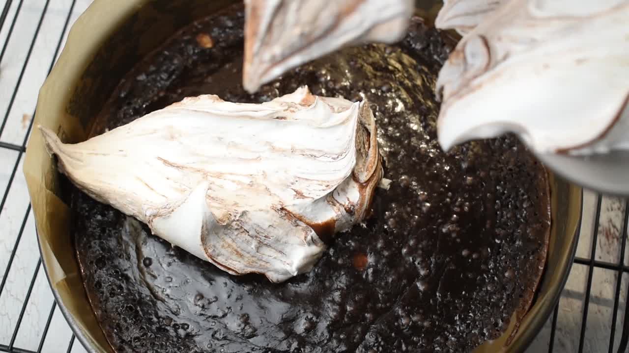 브라우니 케이크 위에 홈메이드 머랭과 초콜릿을 더하는 모습