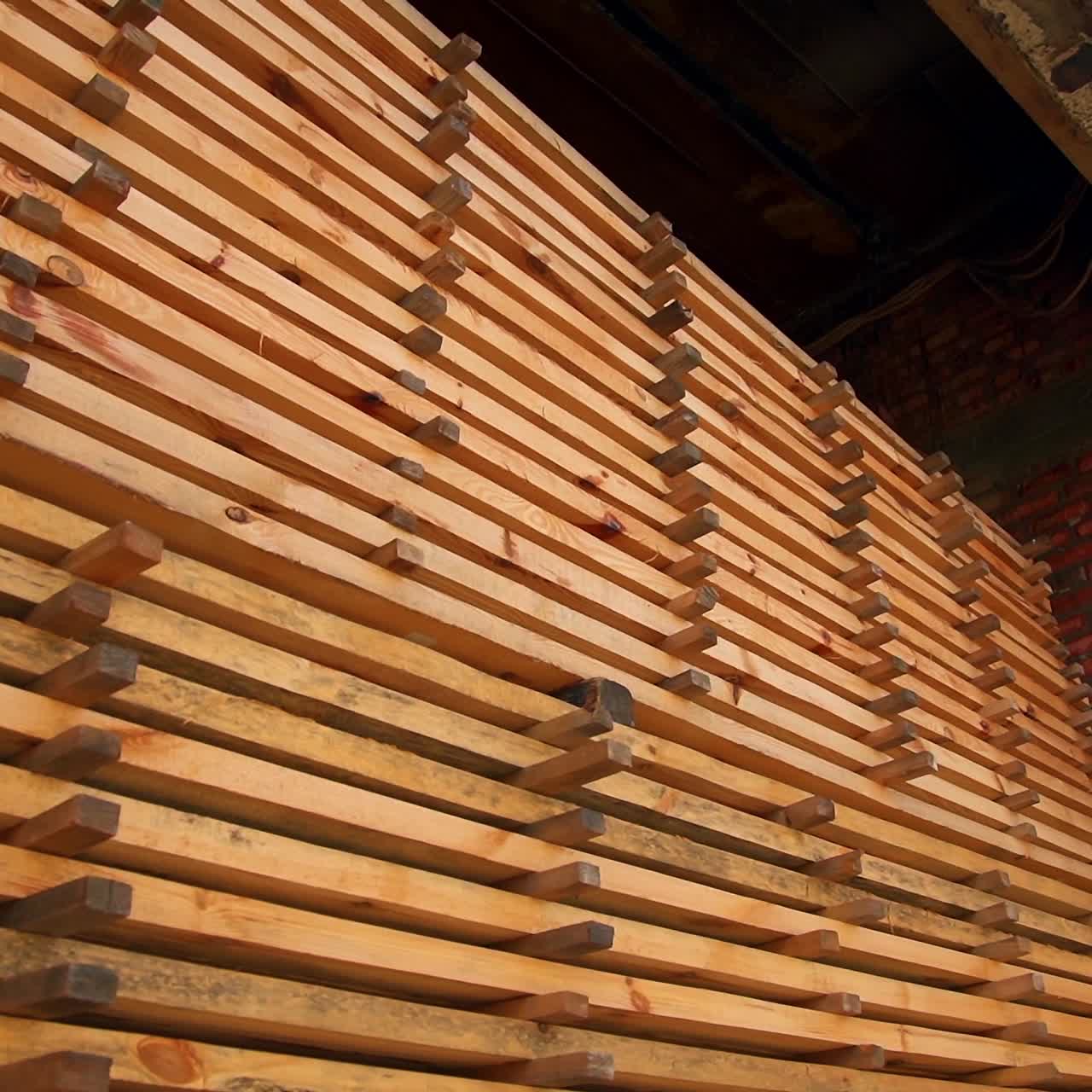 The pile of timber bricks stored in the warehouse. Materials prepared for wood products manufacturing
