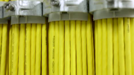 Extreme-close-up-tedious-arranged-yellow-cables-fixed-with-metal-clamp