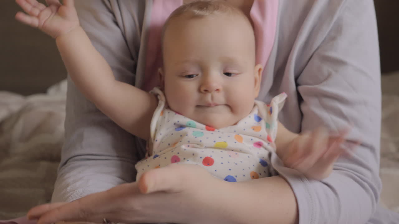 아기 소녀는 엄마의 손을 박는 것을 좋아합니다.