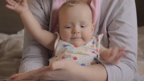 baby girl likes clapping mothers hand