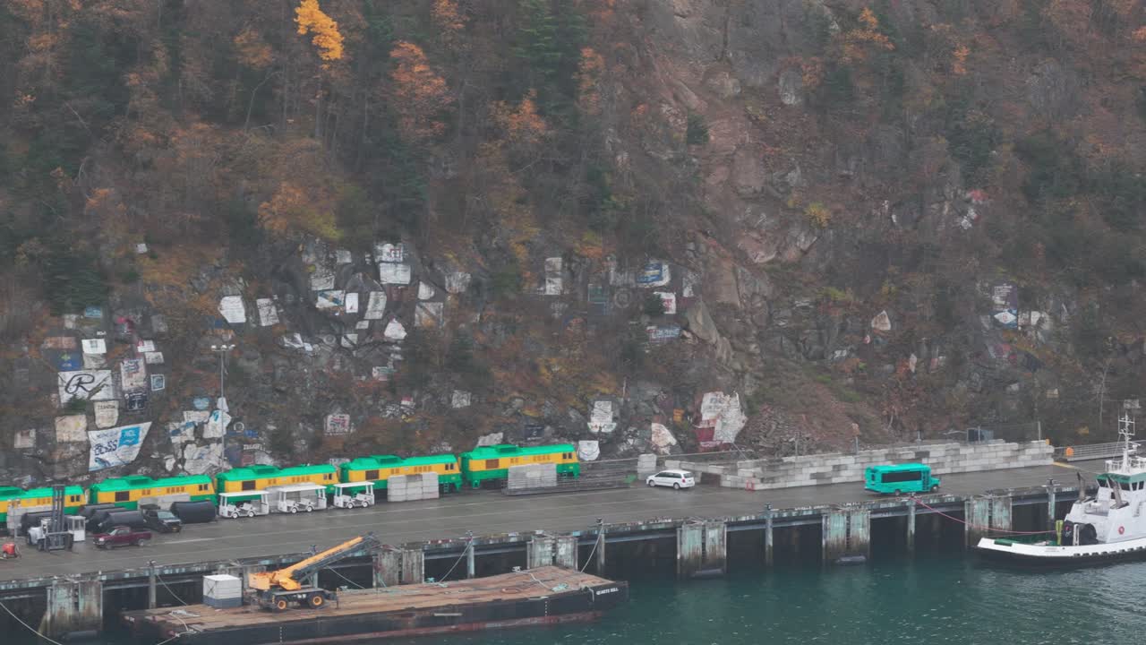 Low aerial dolly shot of the Ship Signature Wall at the port of Skagway in Southeast Alaska. 4K