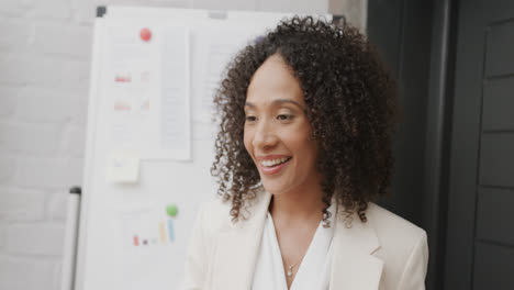 Glückliche-Biracial-Geschäftsfrau-Am-Whiteboard,-Die-Bei-Einer-Bürobesprechung-In-Zeitlupe-Spricht