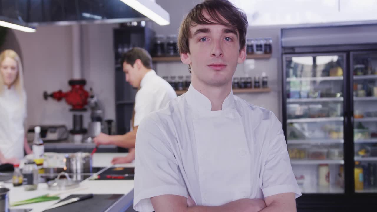 레스토랑 주방에서 일하는 백인 남성 요리사, 카메라에 미소 짓고