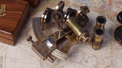 an antique nautical sextant and lenses with a rose wood box on a vintage world map