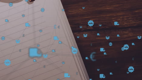 notebook page showing floating blue delivery icons across tilted wooden desk, in flat design