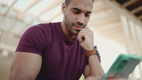 Joven-Enviando-Mensajes-De-Texto-En-Un-Teléfono-Inteligente-Y-Sentado-Al-Aire-Libre.