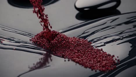 red beads pouring into water