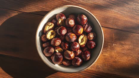 top view of hazelnuts in a bowl on wooden table