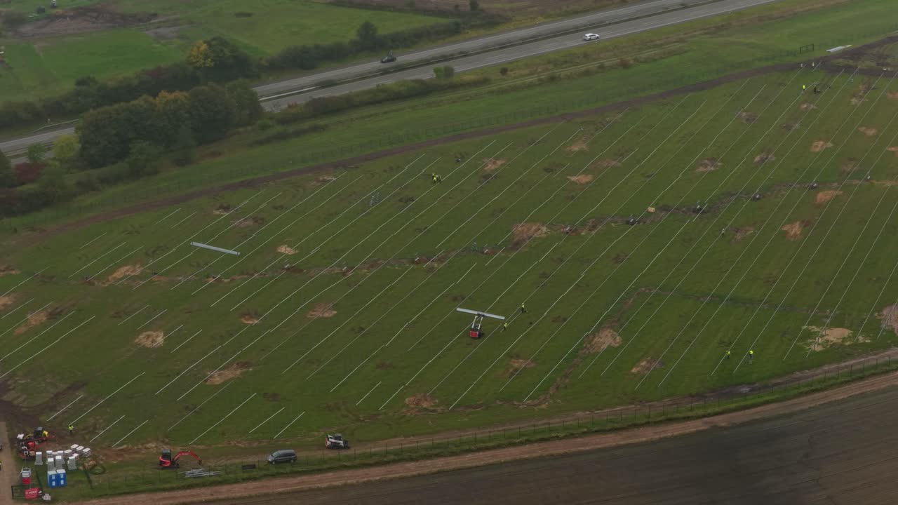 Aerial shot of crew working at solar farm construction site, Germany