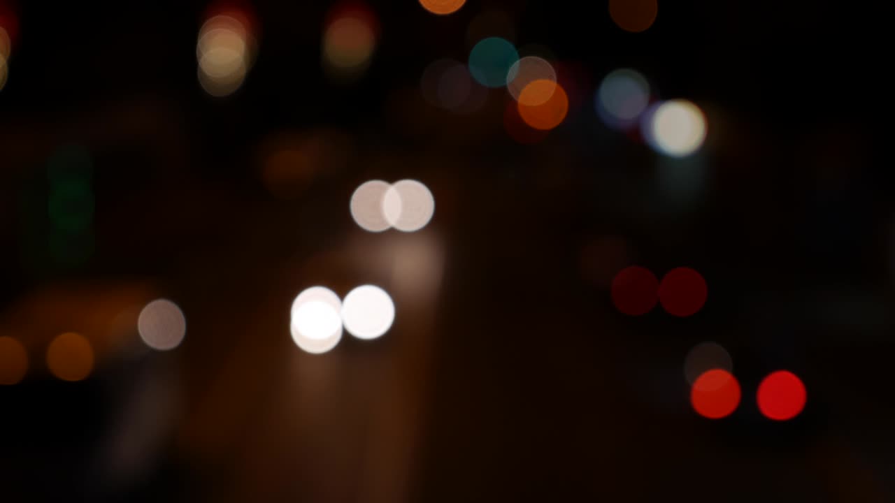 hermoso bokeh brillante en el fondo oscuro borroso por la noche. el redondo bokeh colorido brilla de las luces de los coches en la calle de la ciudad. fuera de foco con borroso. luces de la ciudad sin enfoque. bokeh de tráfico. concepto abstracto