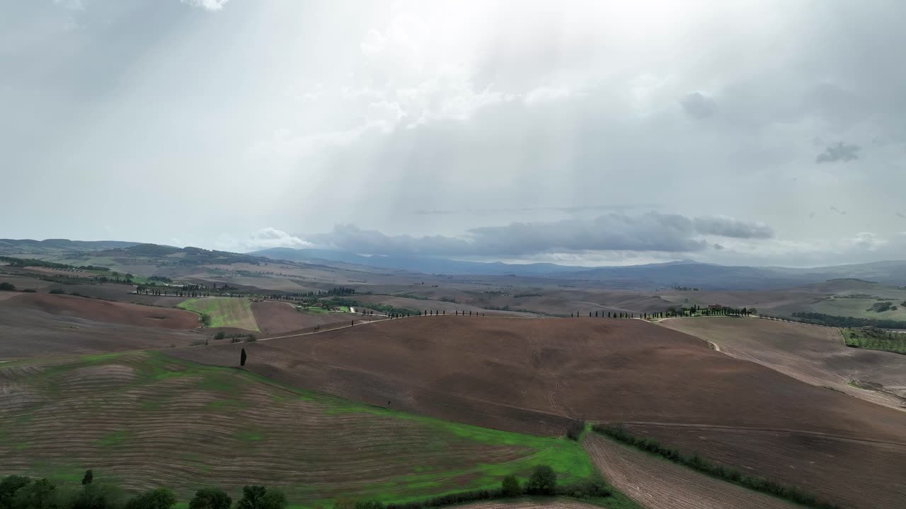 luz del sol a través de las nubes sobre el valle de val d'orcia en la provincia de siena, toscana, italia
