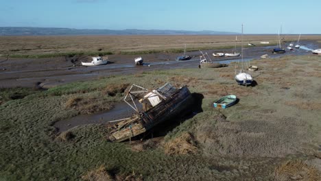 Gestrandetes-Verlassenes-Fischerboot-Wrack-Werft-In-Sumpfschlamm-Ebbe-Küste-Luftbild-Umlaufbahn-Rechts