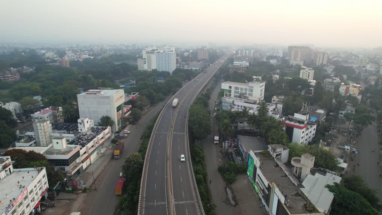 Autostrada nazionale Mumbai-Agra che attraversa il viadotto sopraelevato della città di Nashik, città di secondo livello, città di Nashik coperta da denso smog, inquinamento atmosferico, Maharashtra, drone