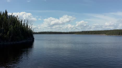 Drone-flying-over-the-waters-of-a-wide-lake-in-summer